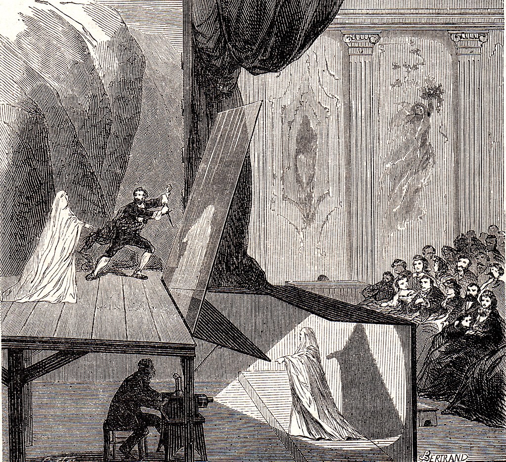 A black and white artistic rendering of the Pepper's Ghost Effect, drawn in the style of an etching. A theater audience, seated to the right of the frame watches an actor on the stage. Beneath the stage a projectionist shines a bright light on a second actor, who is dressed as a ghost. Both are out of sight of the audience. There is a sheer film suspended between the stage and the audience, which is capturing the reflection of the actor dressed as a ghost beneath the stage. Because of the viewing angle, it appears to the theater audience that this reflection stands onstage with the visible actor, creating a ghost.