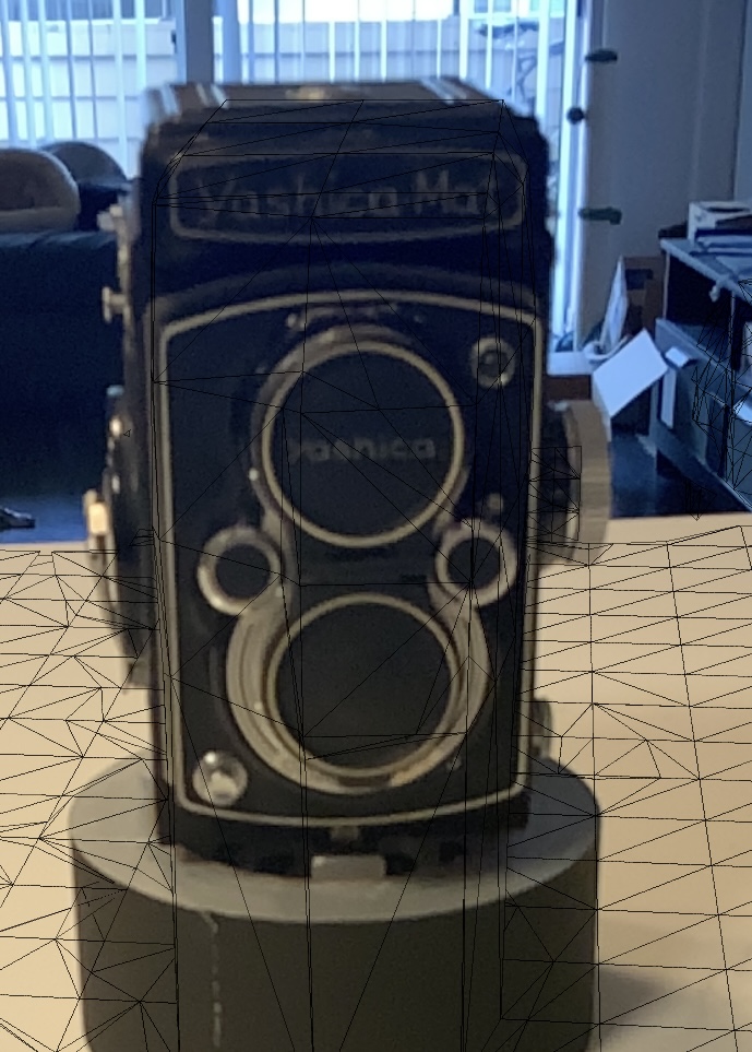 Image of an antique camera with a wireframe mesh projected onto it.